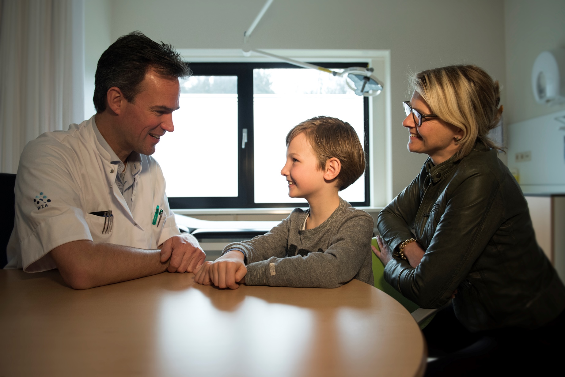 jongetje in spreekkamer met arts en moeder